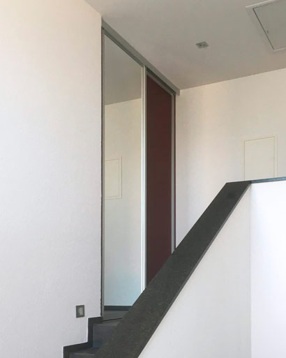 Schreinerei Elser, Garderobenlösung mit Schiebetüren im Treppenaufgang